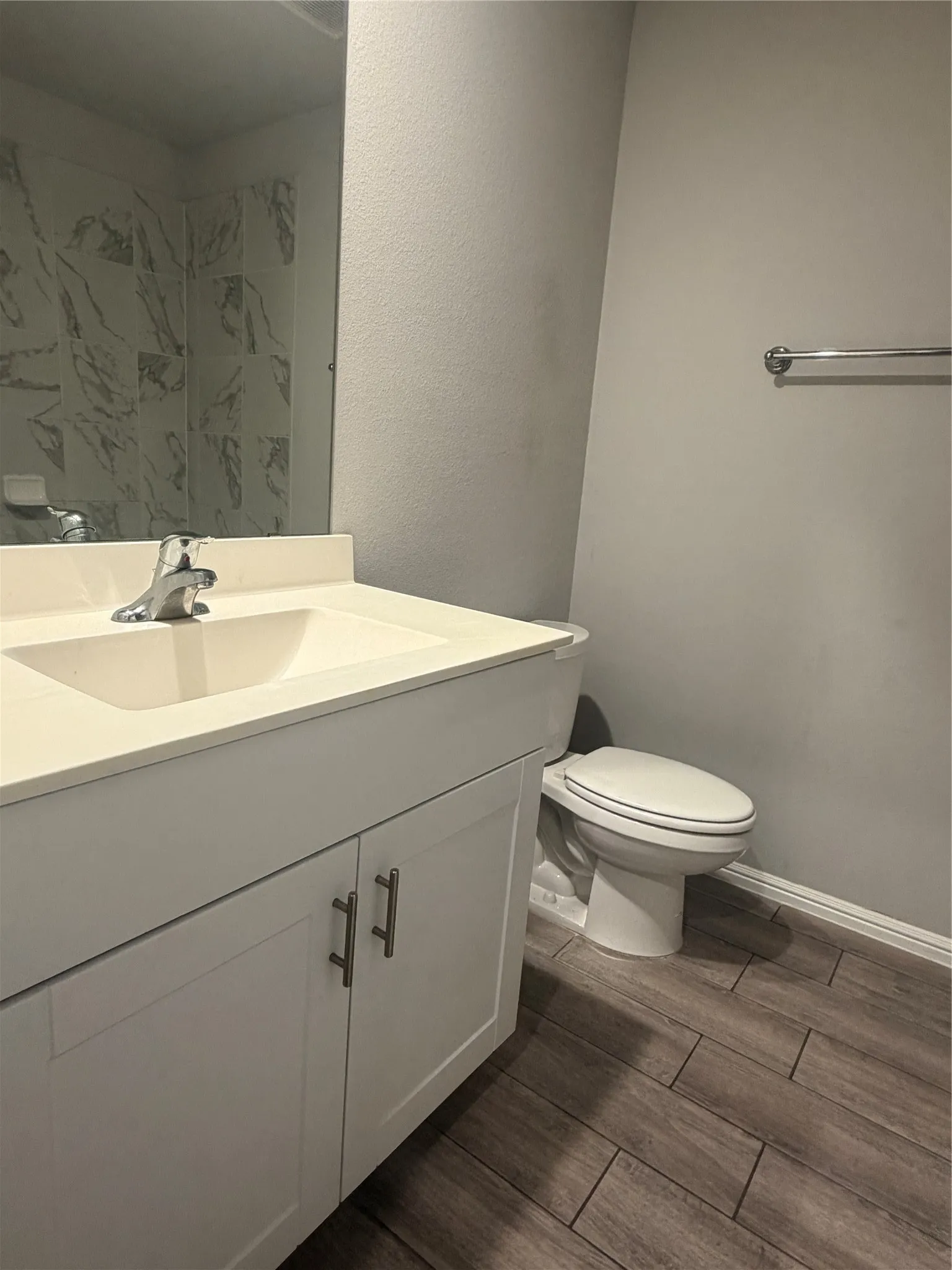 White vanity with integrated rectangular sink, chrome faucet, and white countertop