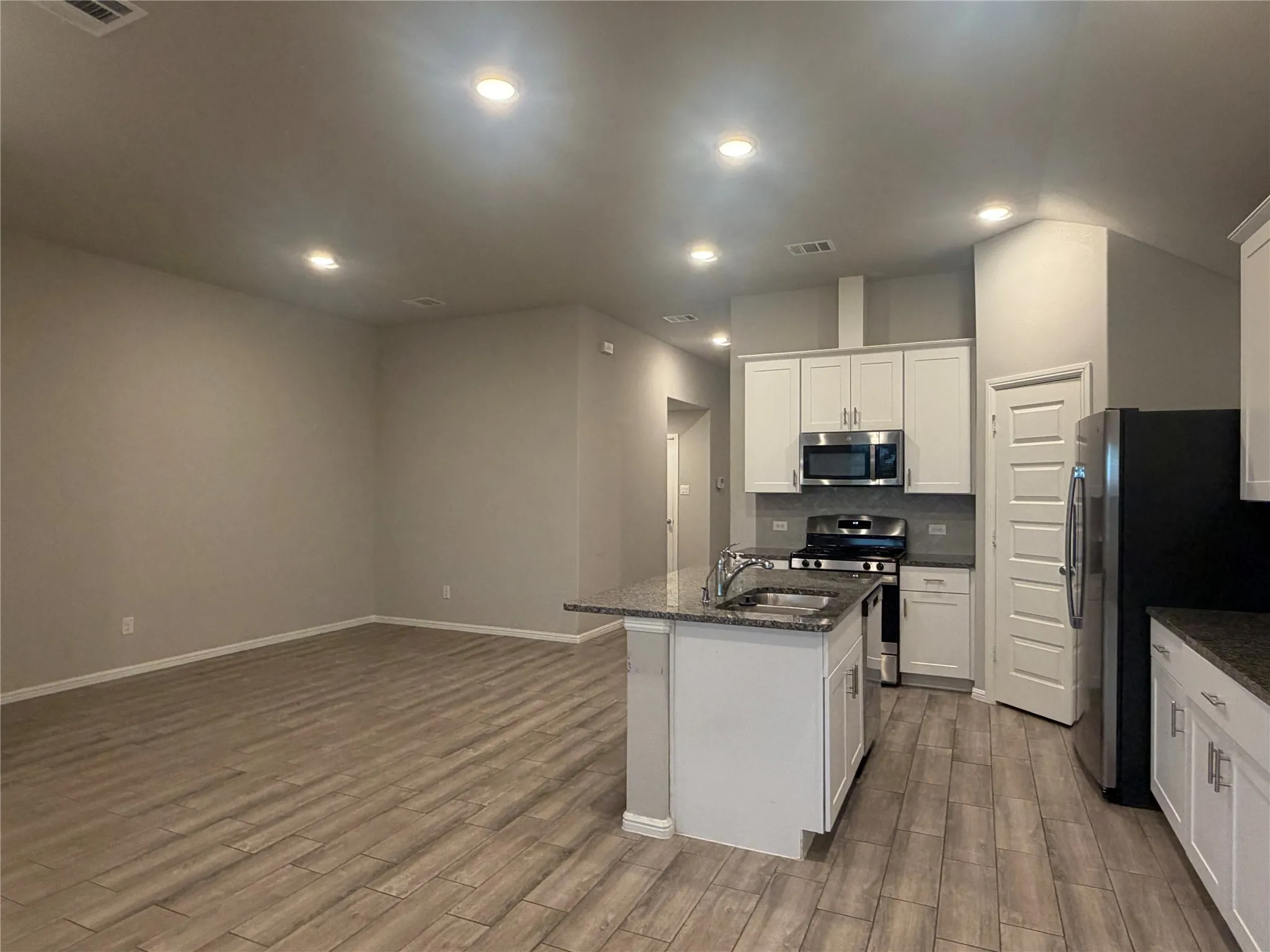 Kitchen island with an undermount sink, granite-style countertop, and chrome faucet