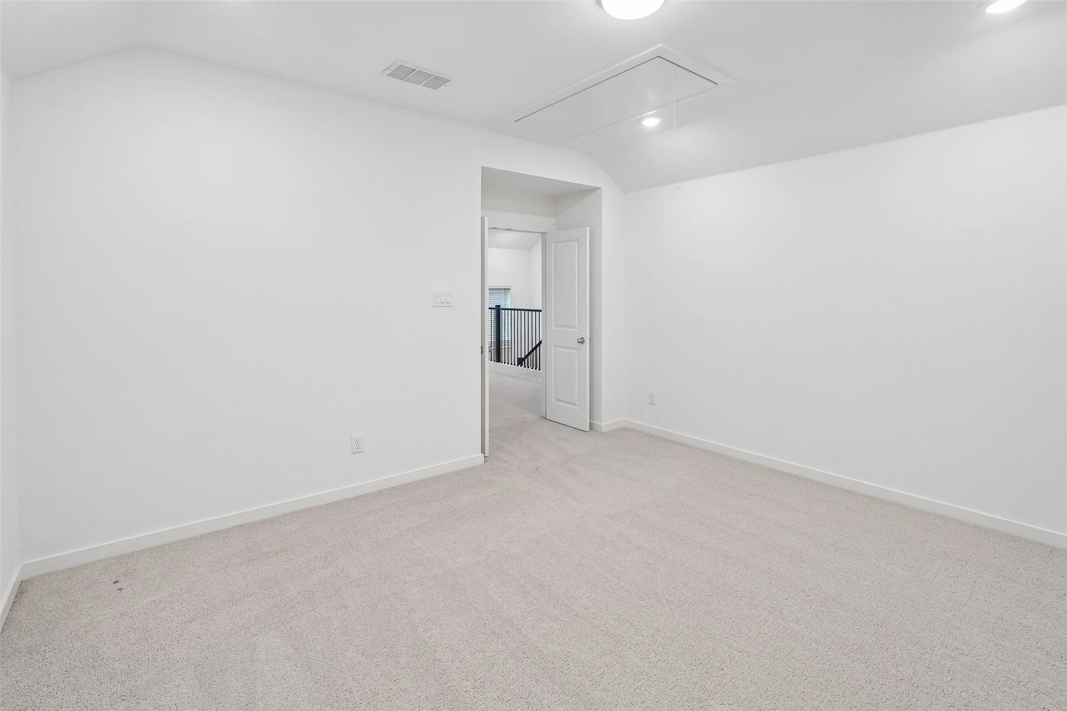 Spacious room with light-toned carpeting, recessed lighting, and a neutral color palette