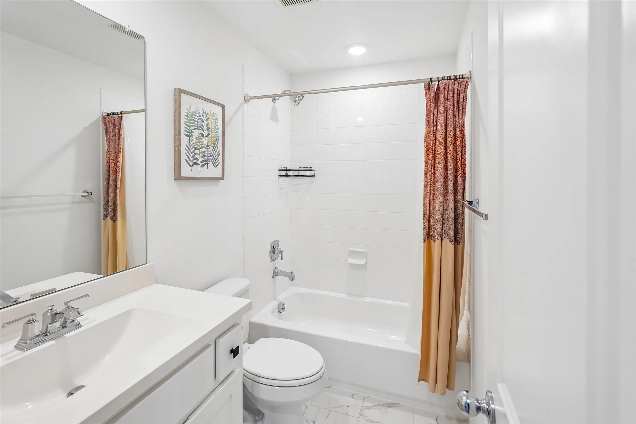 Bathroom featuring a white vanity with an integrated sink, polished chrome faucet, and a large wall mirror