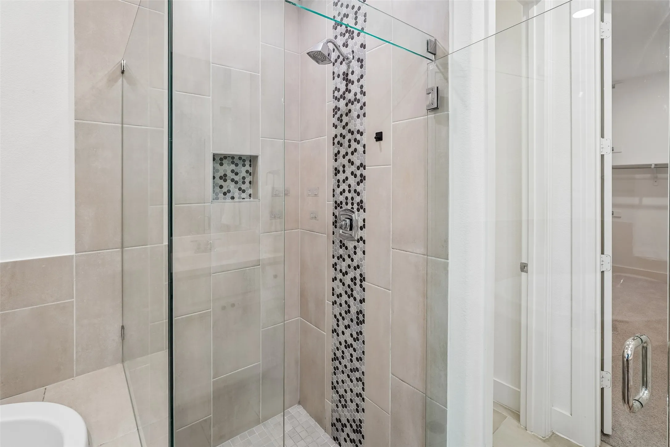 Glass-enclosed shower with a rainfall showerhead, integrated mosaic tile accent, and a recessed tiled niche