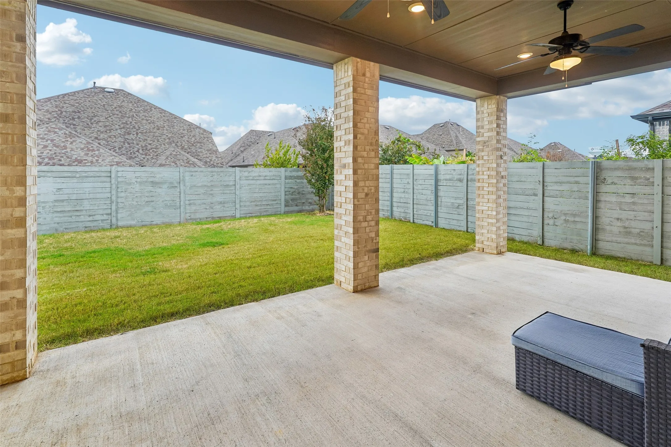 Covered patio featuring brick pillars, two ceiling fans, recessed lighting, and a concrete slab