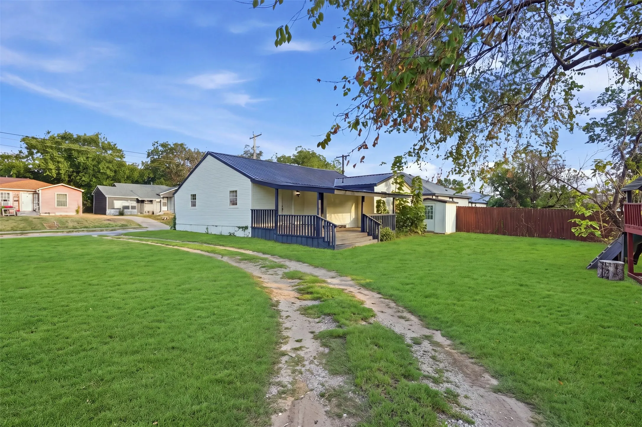 Expansive green lawn with a dirt path