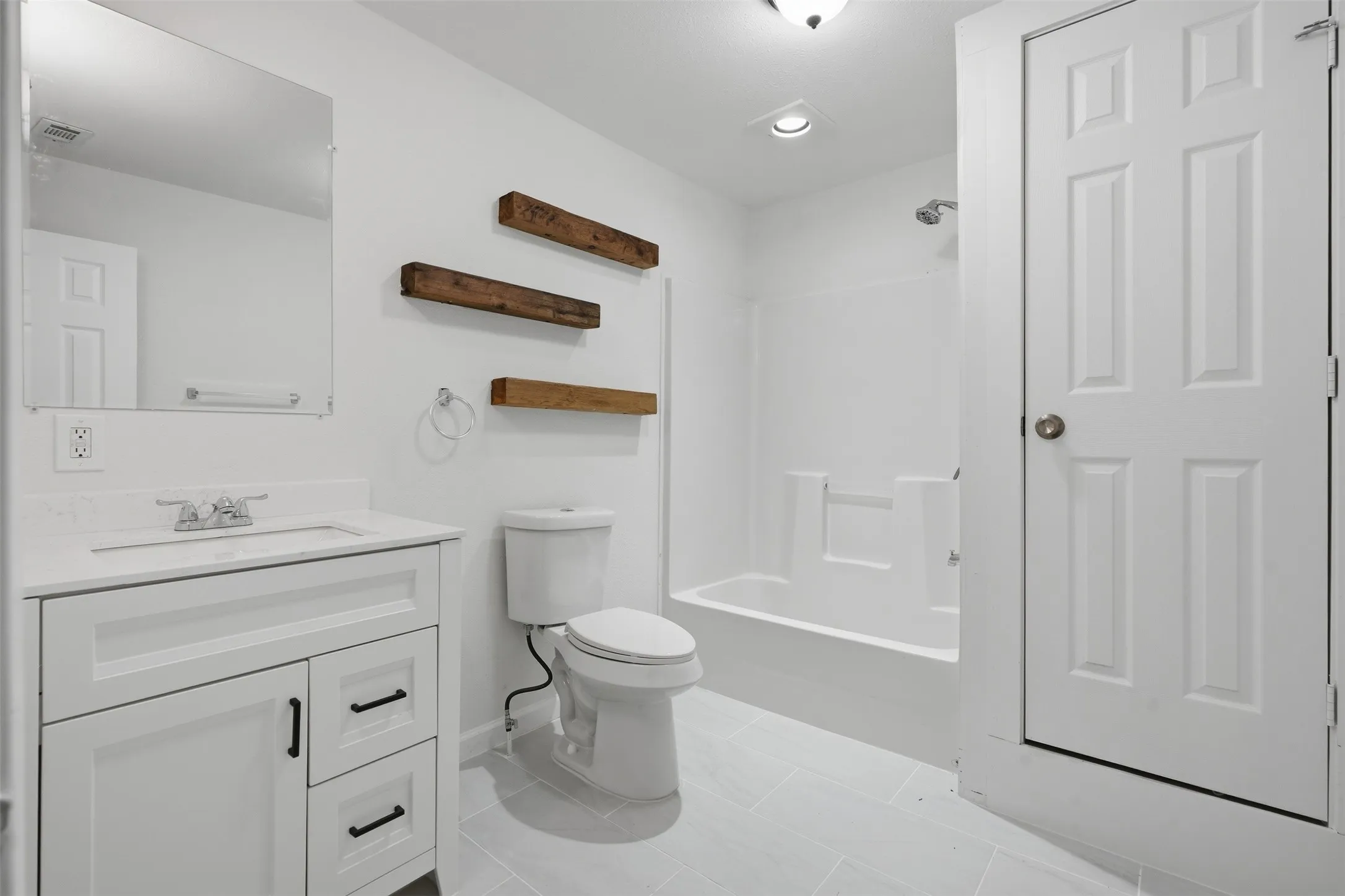 White vanity with matte black hardware, white countertop, and integrated sink