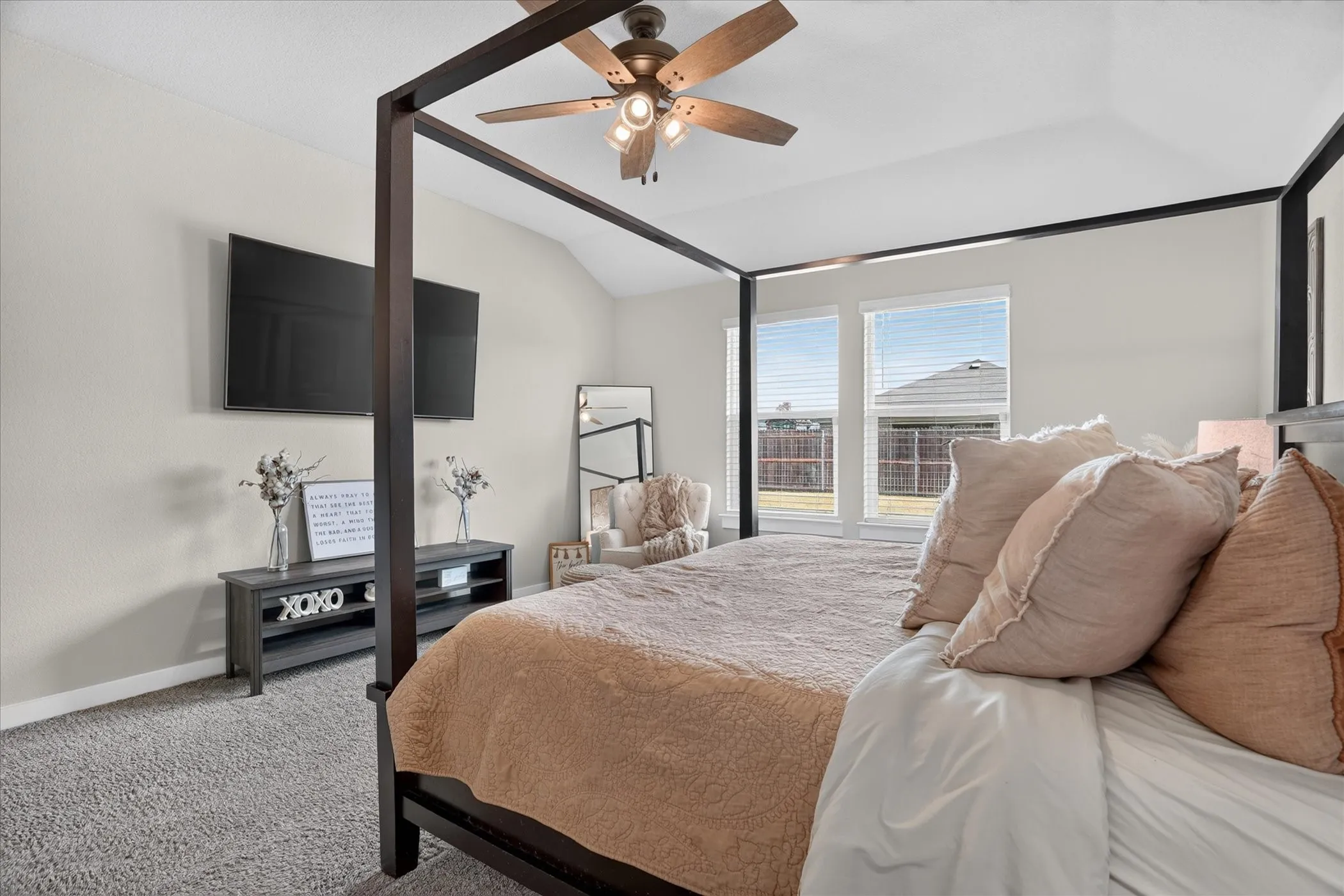 Vaulted ceiling with a ceiling fan, two windows with blinds, and light-toned wall paint