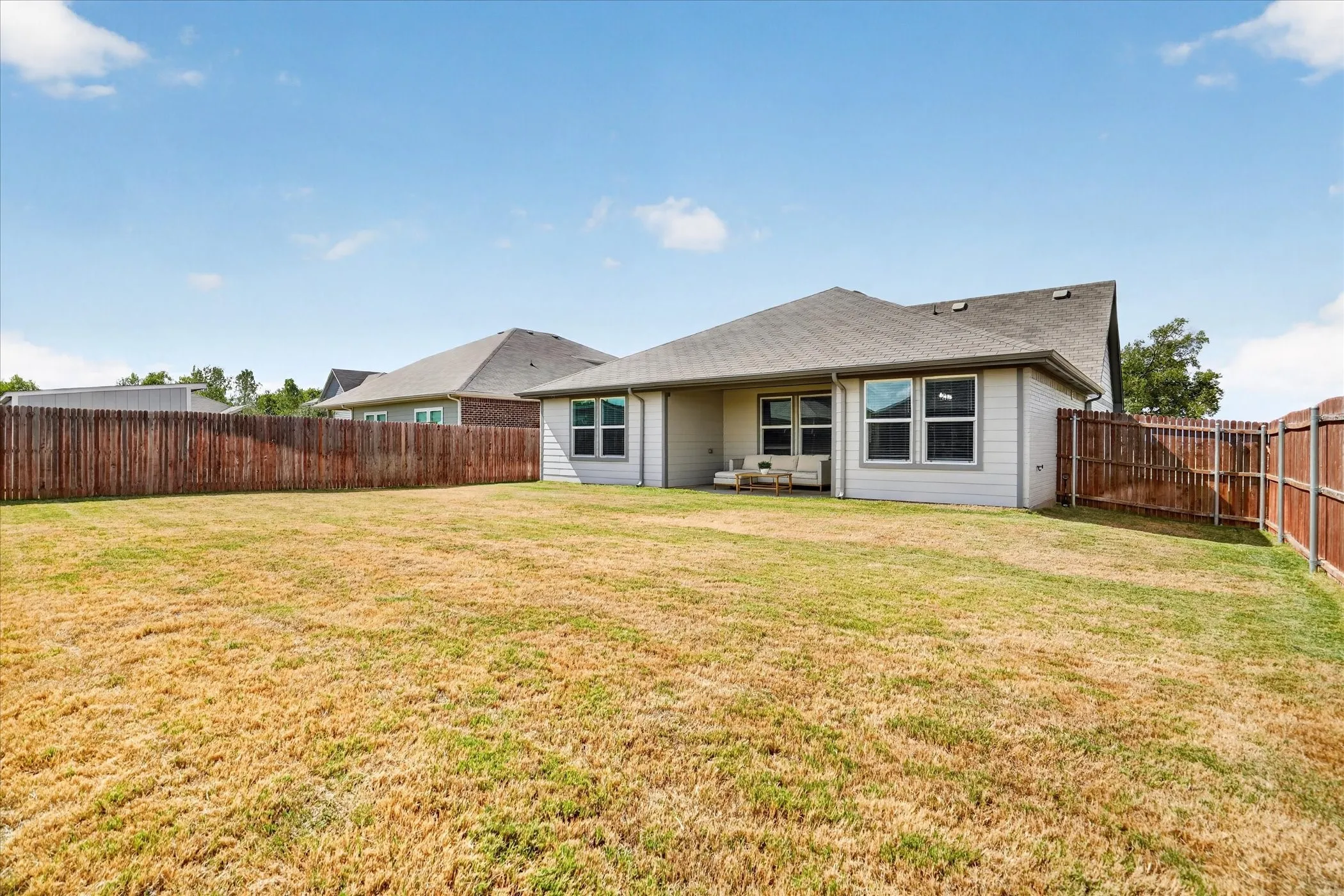 Expansive backyard with wood fencing and a concrete patio