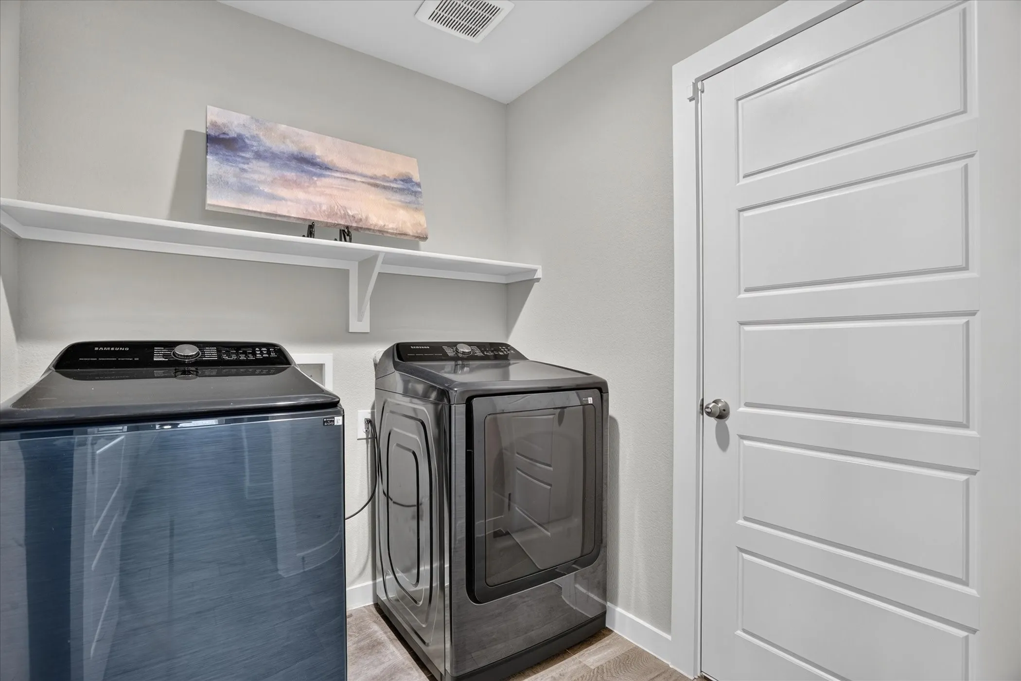 Built-in shelving, wood-finish flooring, and a white paneled door