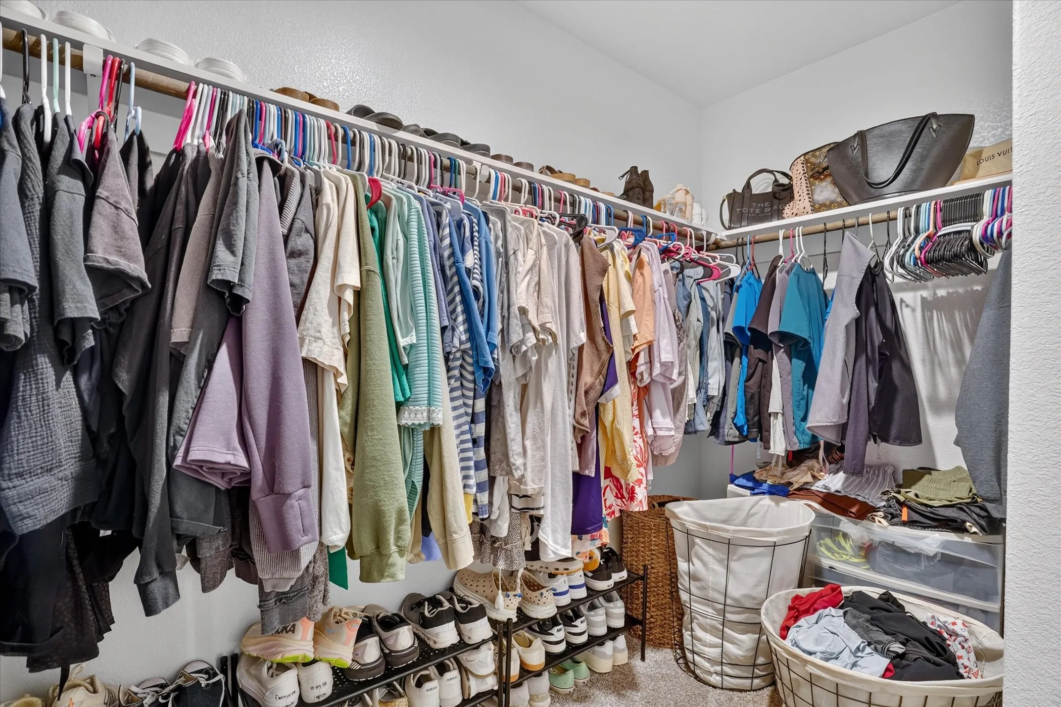 Walk-in closet featuring multiple hanging rods off primary ensuite.