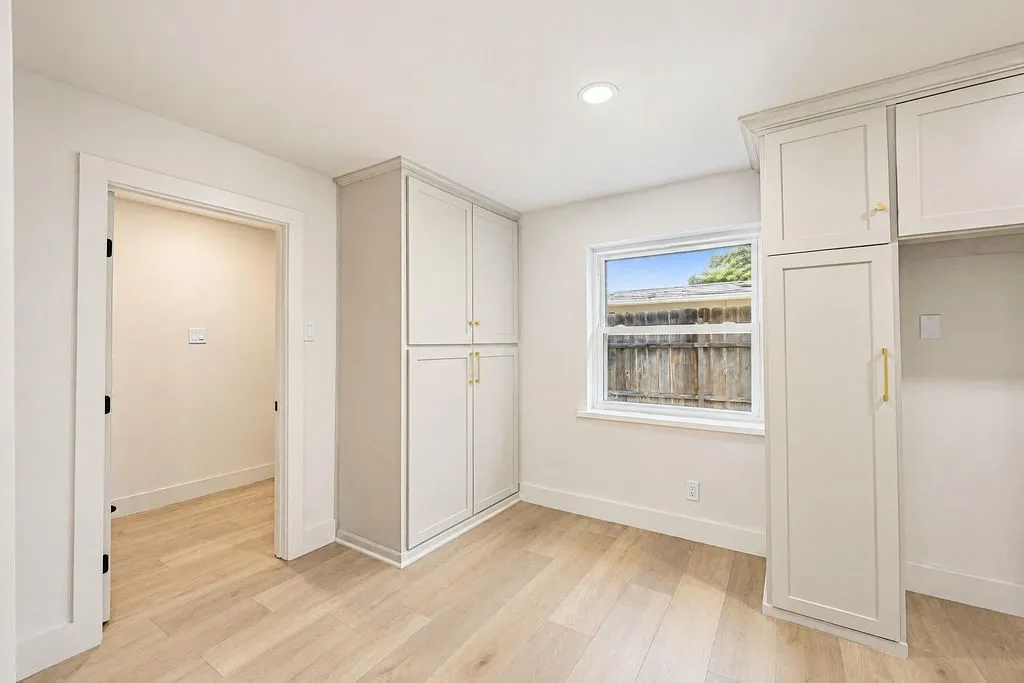 Light wood-finish flooring with white baseboards