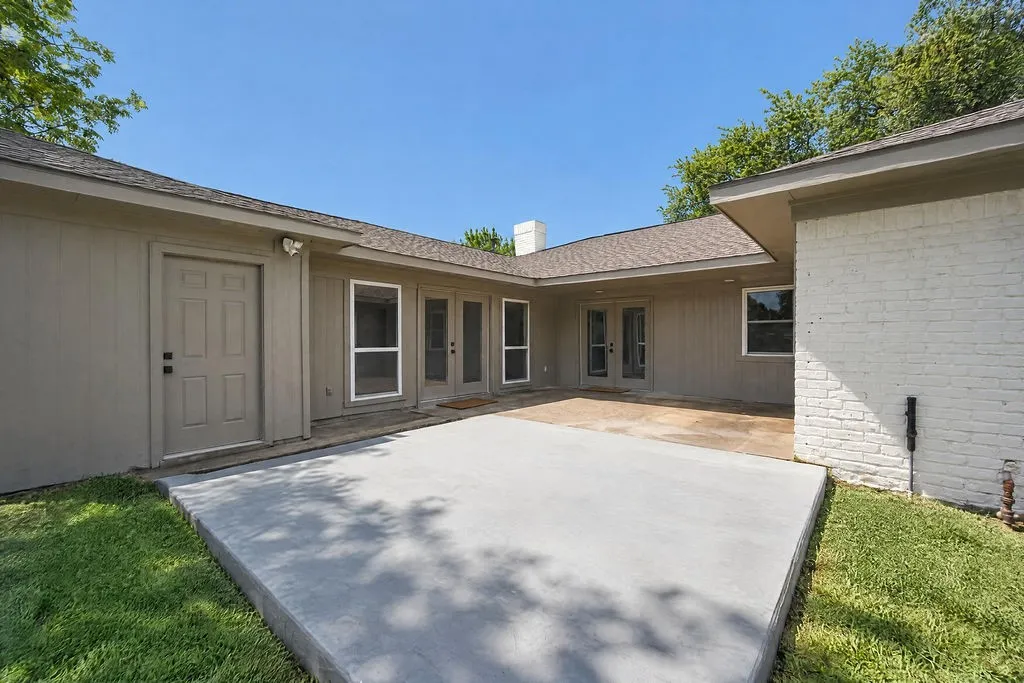 Expansive concrete patio with an additional stone patio area