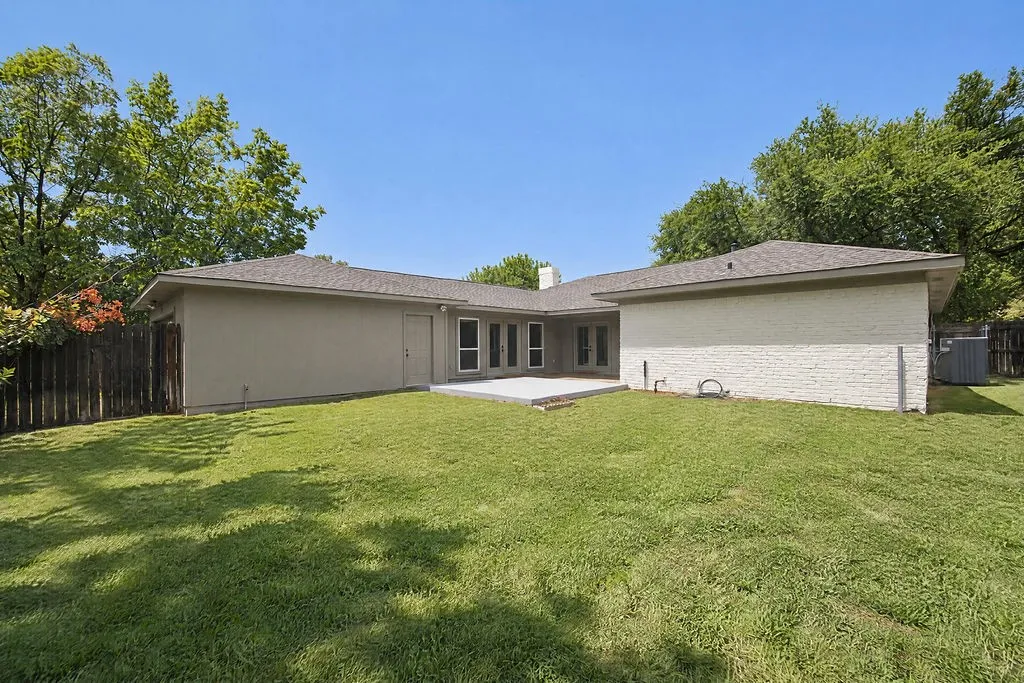 Expansive backyard with a manicured lawn, a concrete patio, and a privacy fence