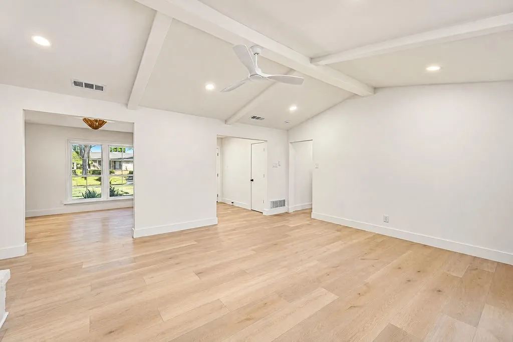 Vaulted ceiling with exposed beams, recessed lighting, wood-finish flooring, and a contemporary ceiling fan