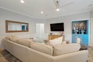 Recessed lighting with a ceiling fan, crown molding, chair rail, built-in media cabinetry, and wood-finish flooring
