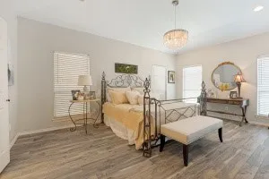 Wood-finish flooring throughout, light neutral wall tones, and multiple windows with blinds