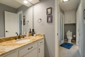 Vanity with a granite countertop, undermount sink, and dark bronze fixtures