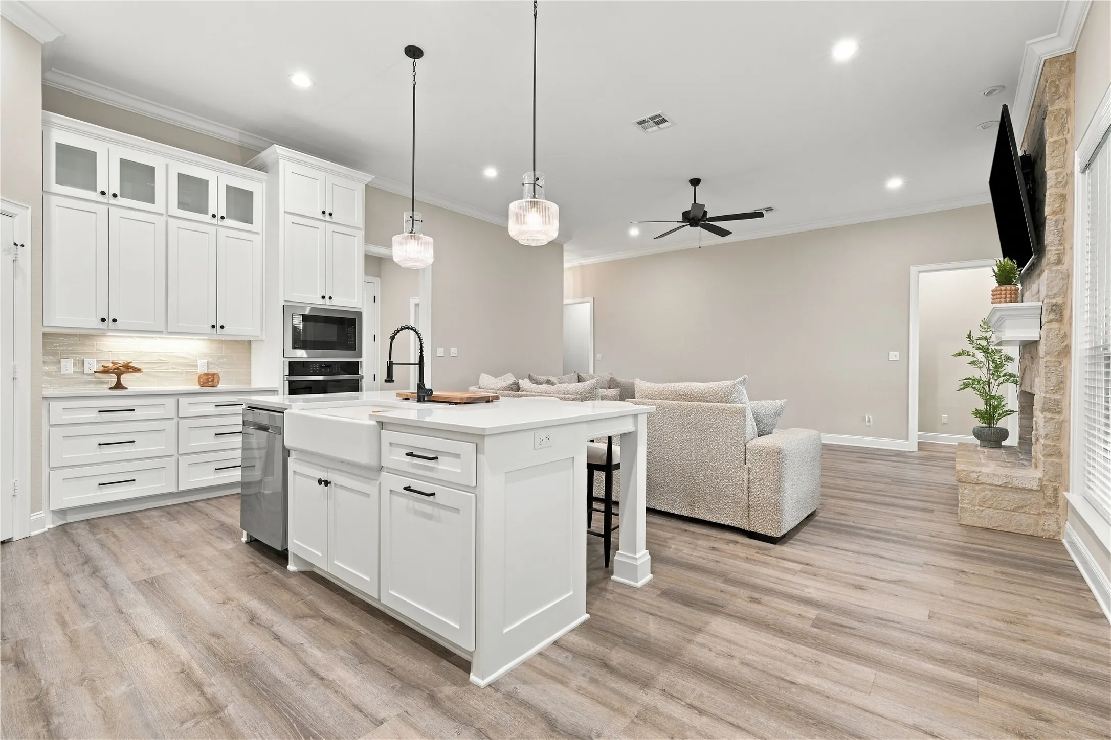 Gourmet kitchen with white shaker cabinetry, an apron-front sink, and built-in appliances