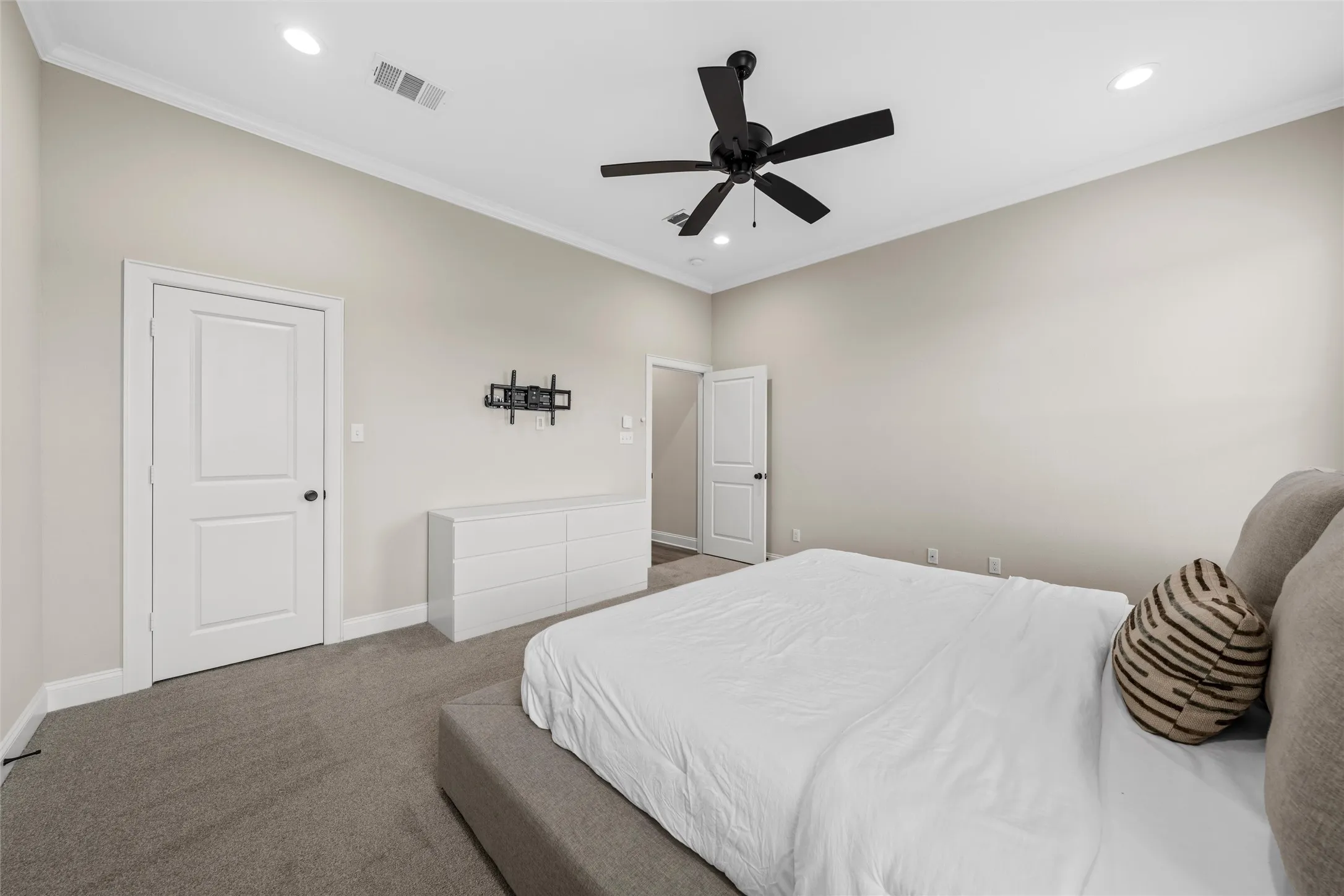 Vaulted ceiling, crown molding, recessed lighting, ceiling fan, and carpeted flooring
