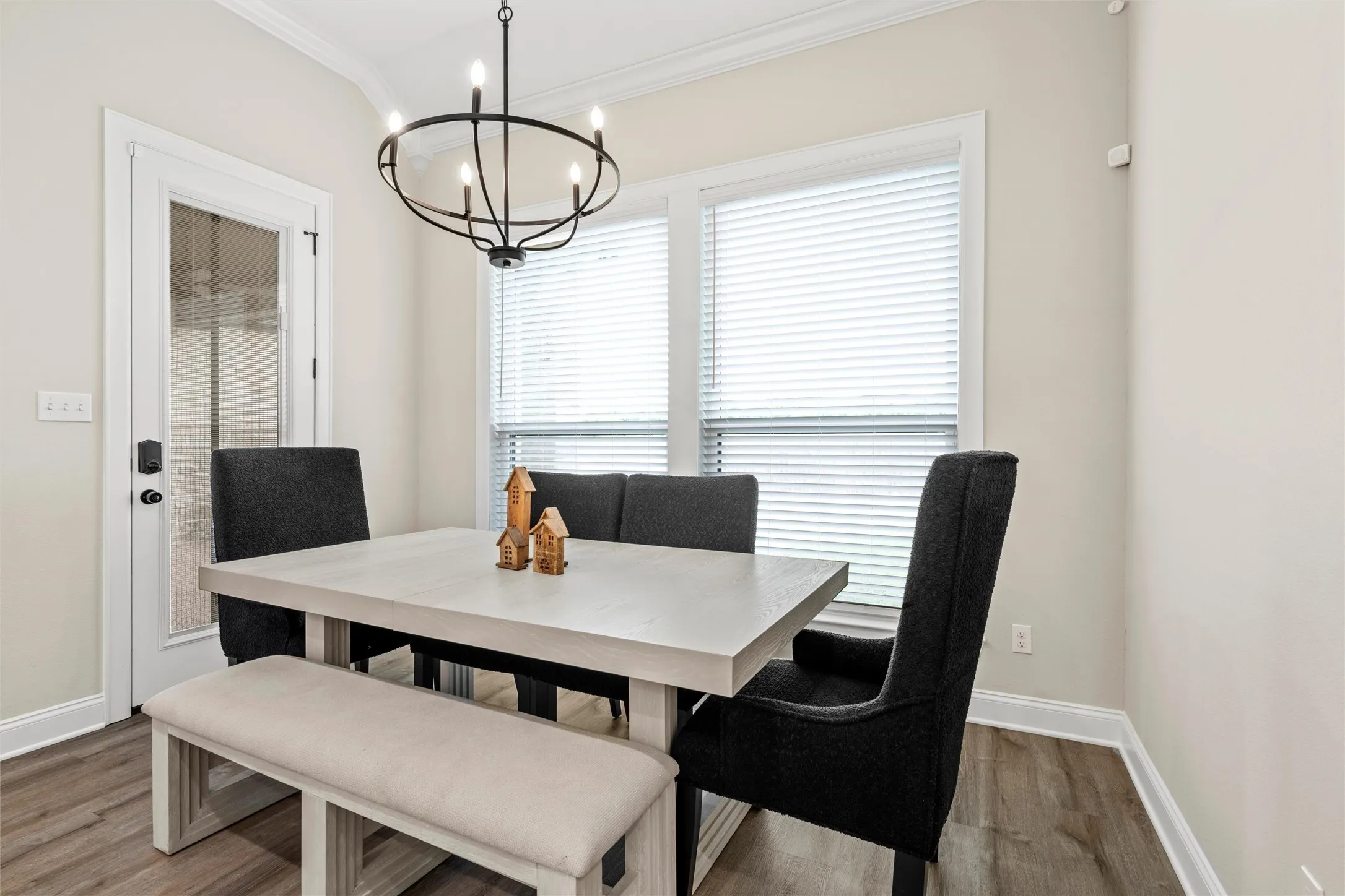 Hardwood-style flooring, crown molding, double pane windows with blinds, and a built-in chandelier
