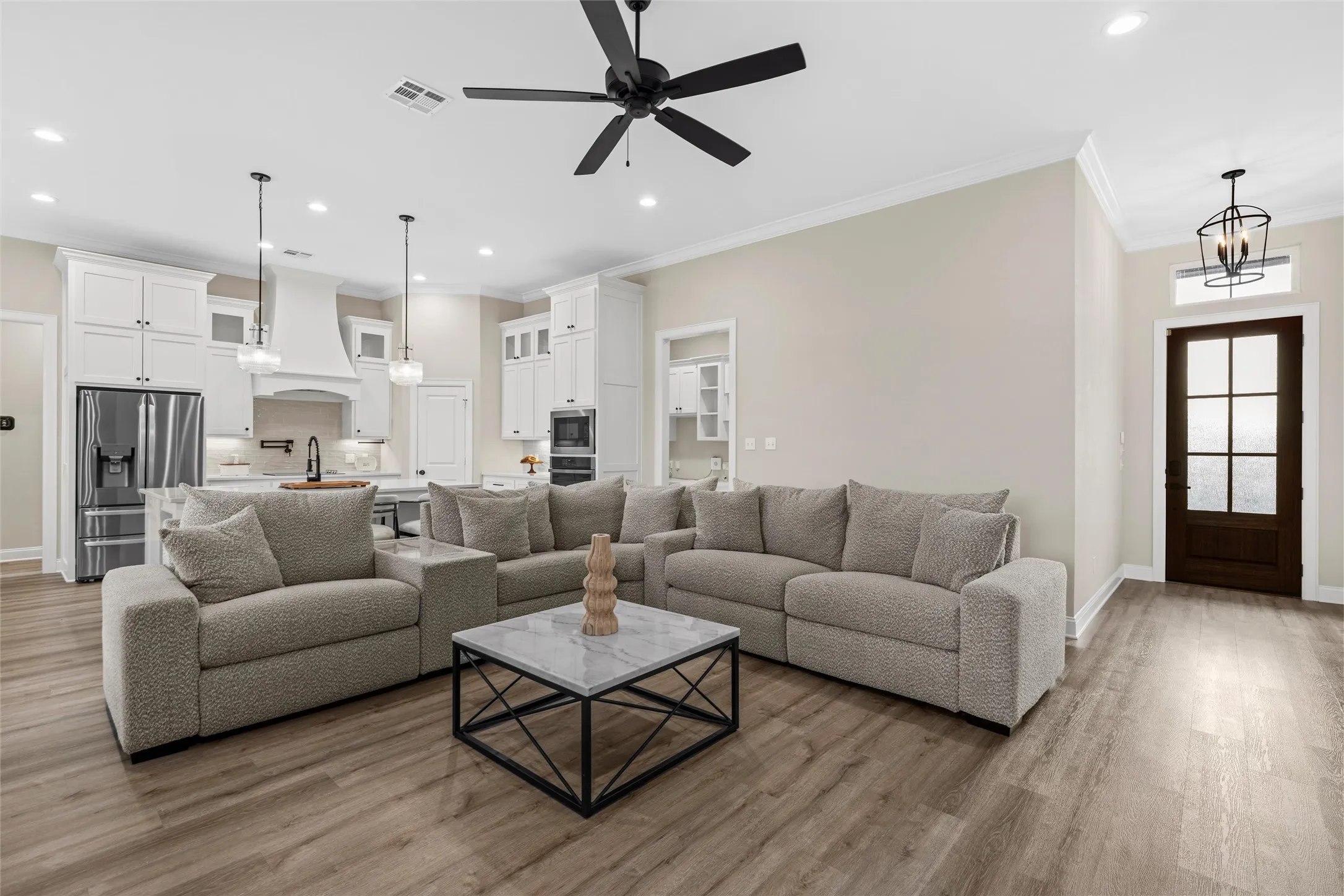 Open-concept living space with wood-finish flooring, a contemporary ceiling fan, and recessed lighting