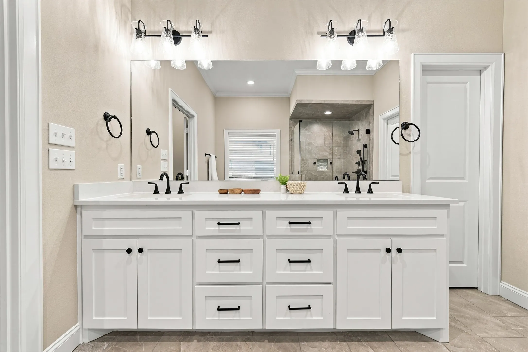 Dual vanity with white shaker cabinetry, matte black hardware, white countertops, and undermount sinks