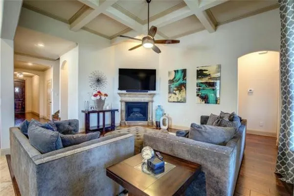 Coffered ceiling, wood-finish flooring, built-in fireplace, and an arched doorway