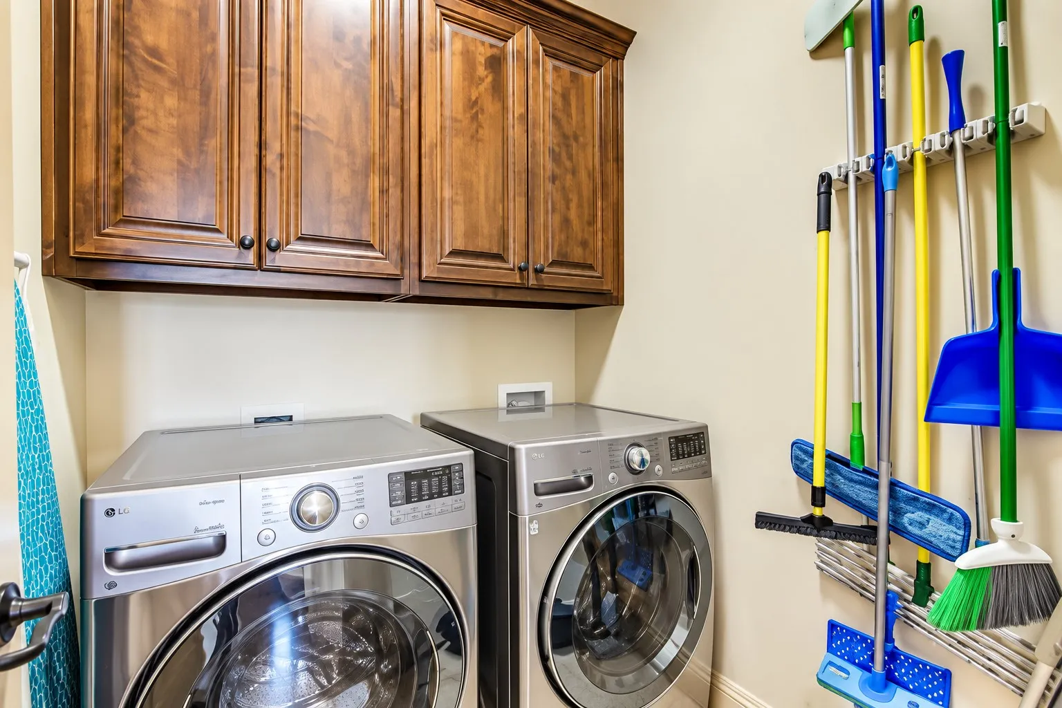 Wall-mounted wood cabinetry, light-toned wall paint, and a wall-mounted utility organizer
