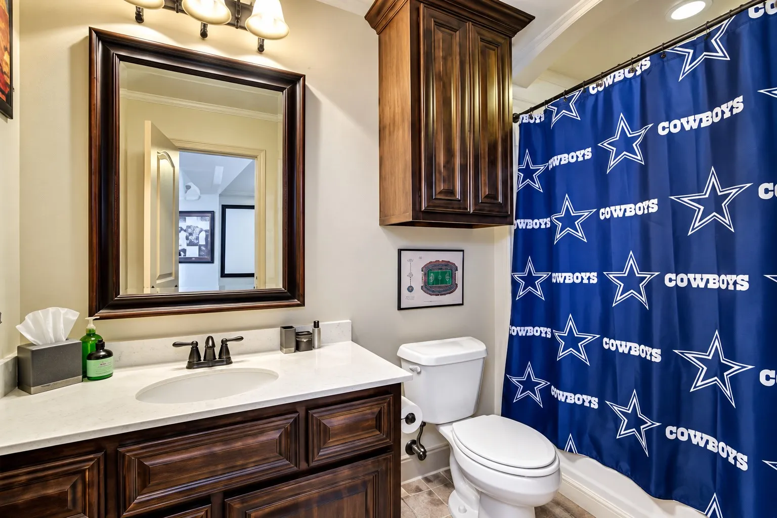 Vanity with dark wood cabinetry and a light-toned countertop, framed mirror, and built-in medicine cabinet