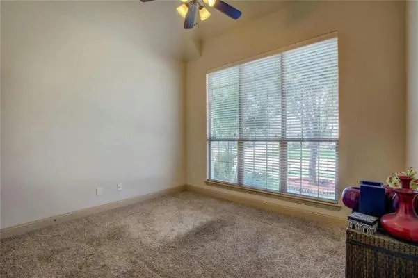 Generous window with blinds, carpeted flooring, and a ceiling fan