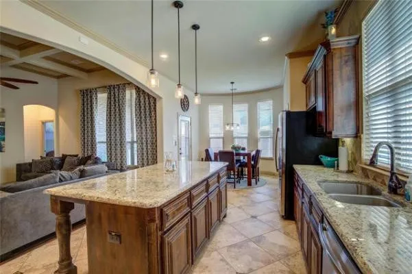 Kitchen featuring granite countertops, wood cabinetry, stainless steel sink, and recessed lighting