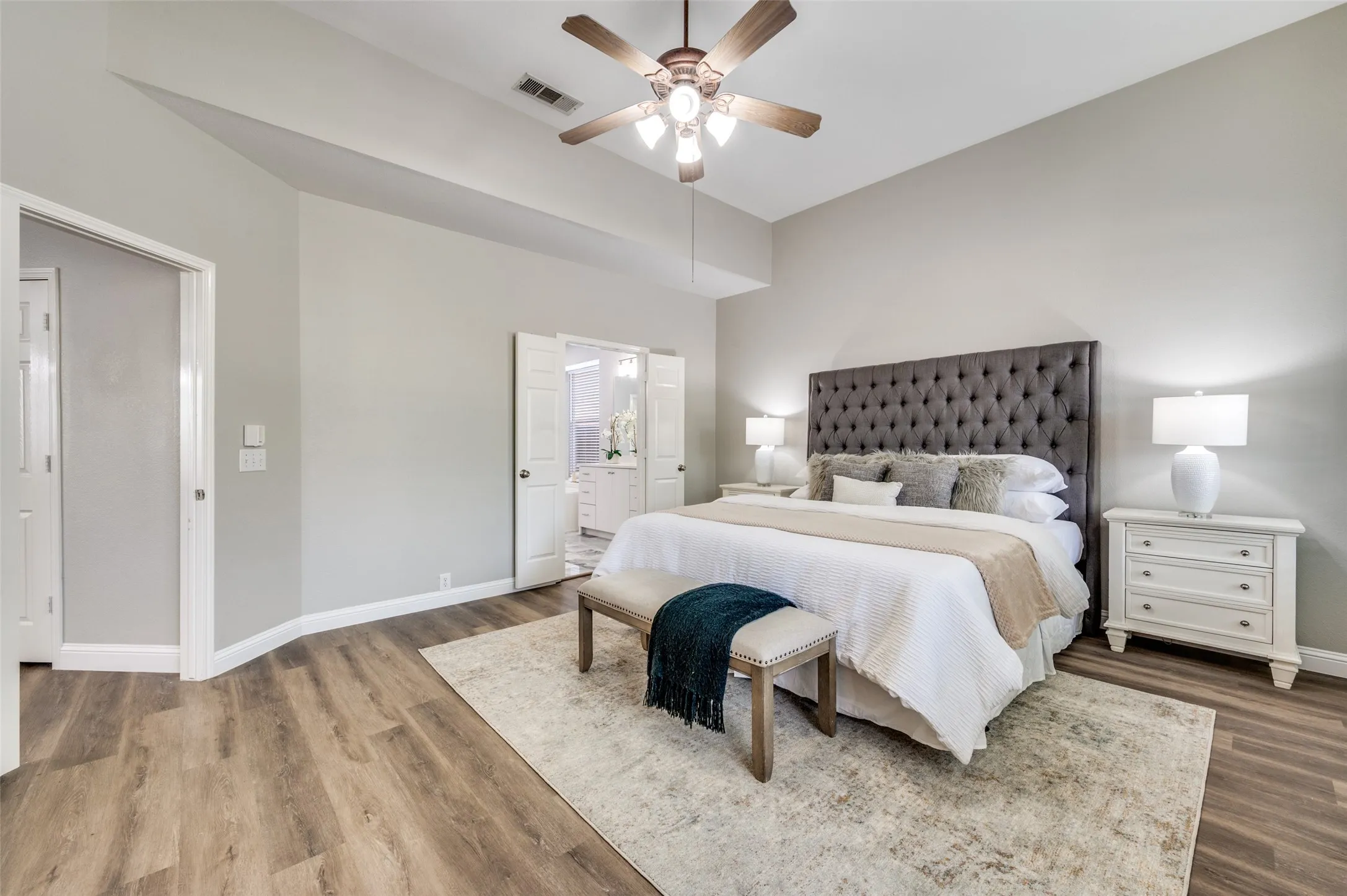 Vaulted ceilings, wood-finish flooring, ceiling fan, and double doors
