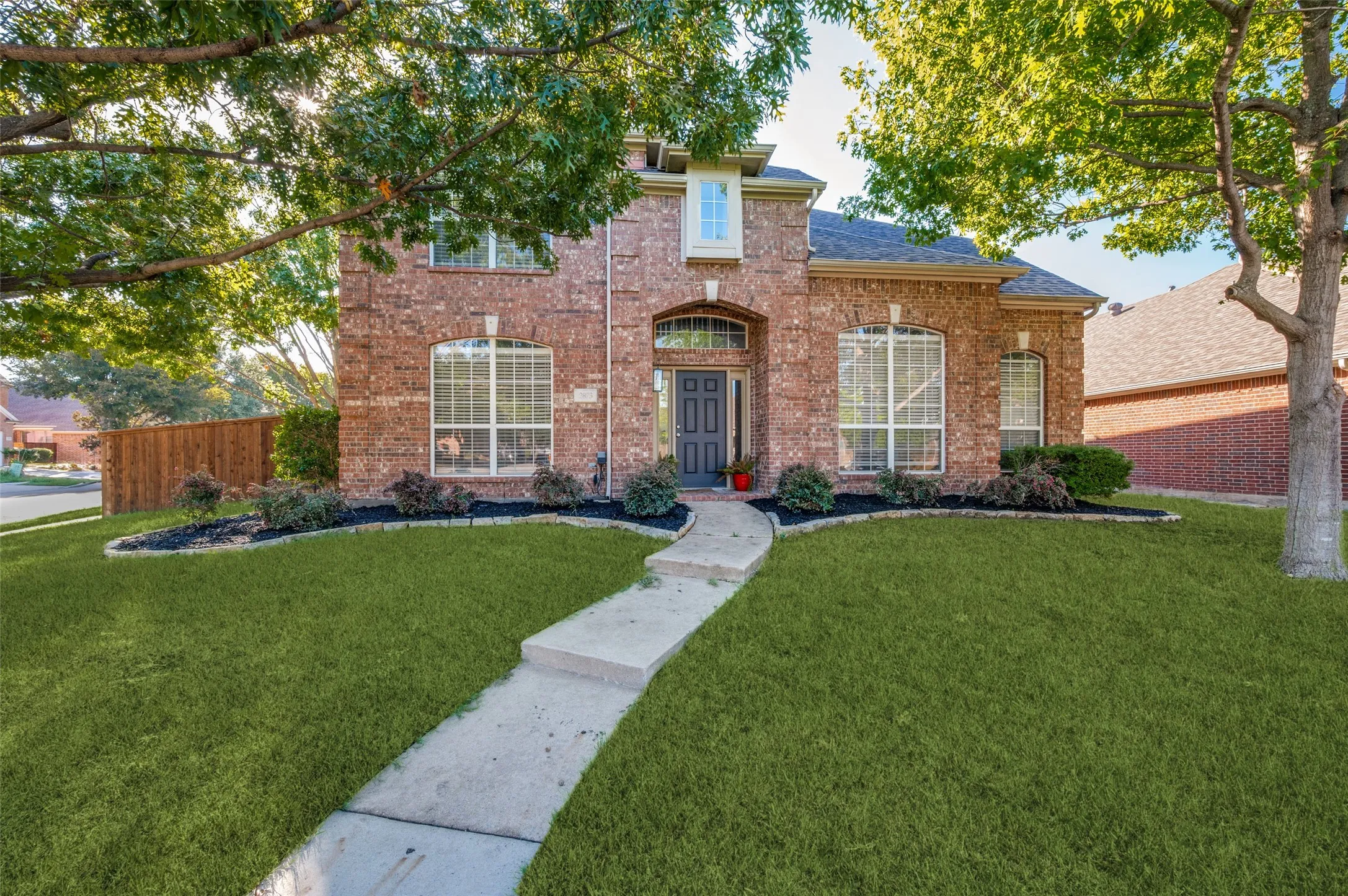 Corner lot! Brick exterior with arched entryway and multiple large windows