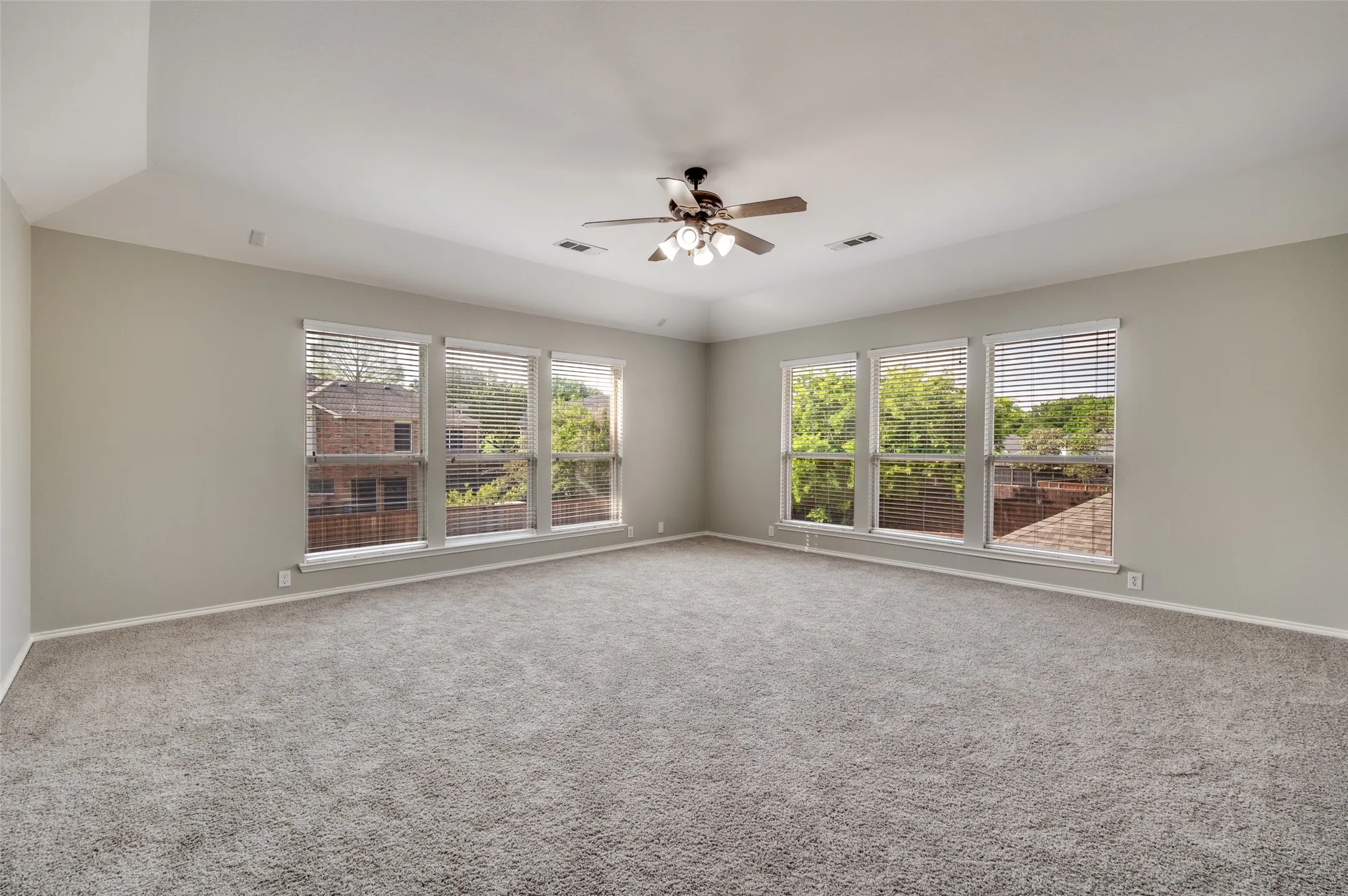additional bonus roomor Media room featuring multiple windows, vaulted ceiling, and a ceiling fan with integrated lighting