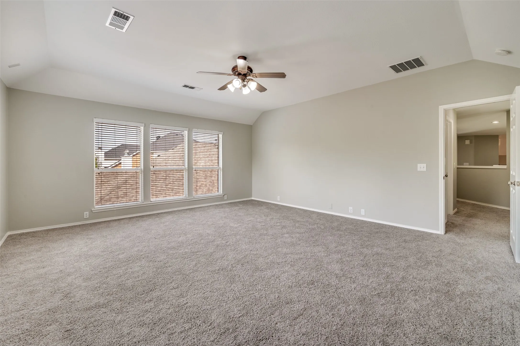 Gameroom with ceiling fan, three pane windows with blinds, light wall finish, and neutral carpet