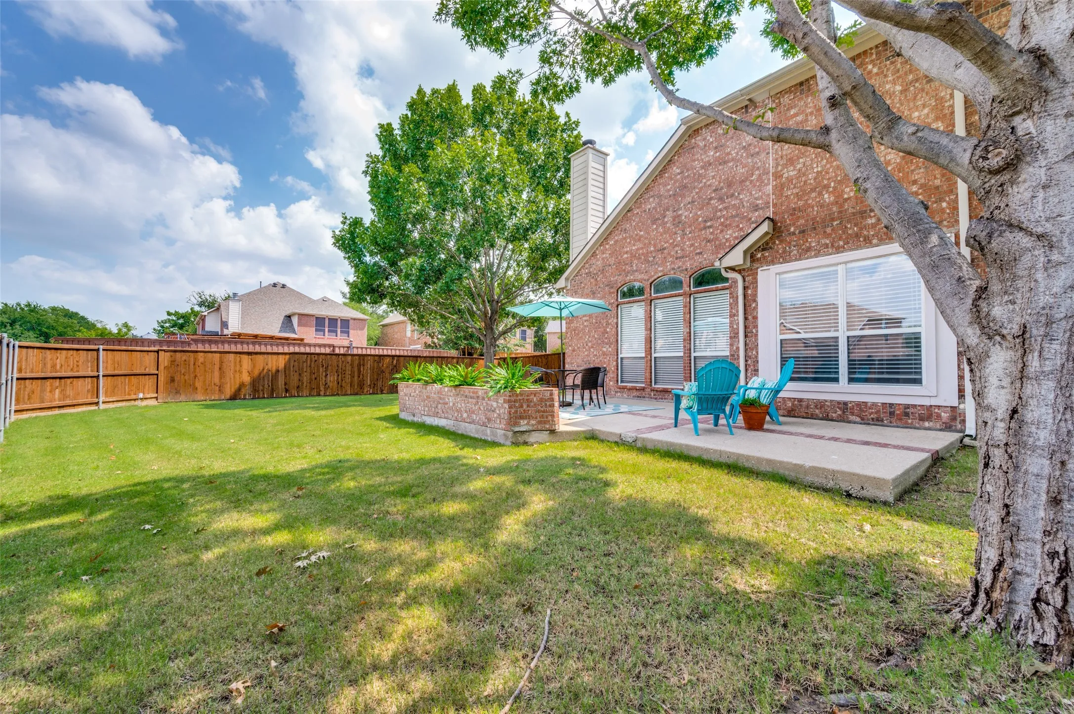 Expansive green lawn with a wood fence perimeter