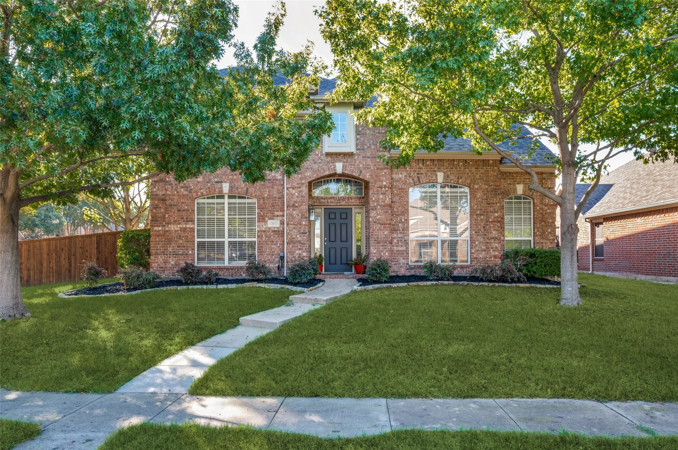 Brick exterior with arched entry, arched windows, and a paved walkway