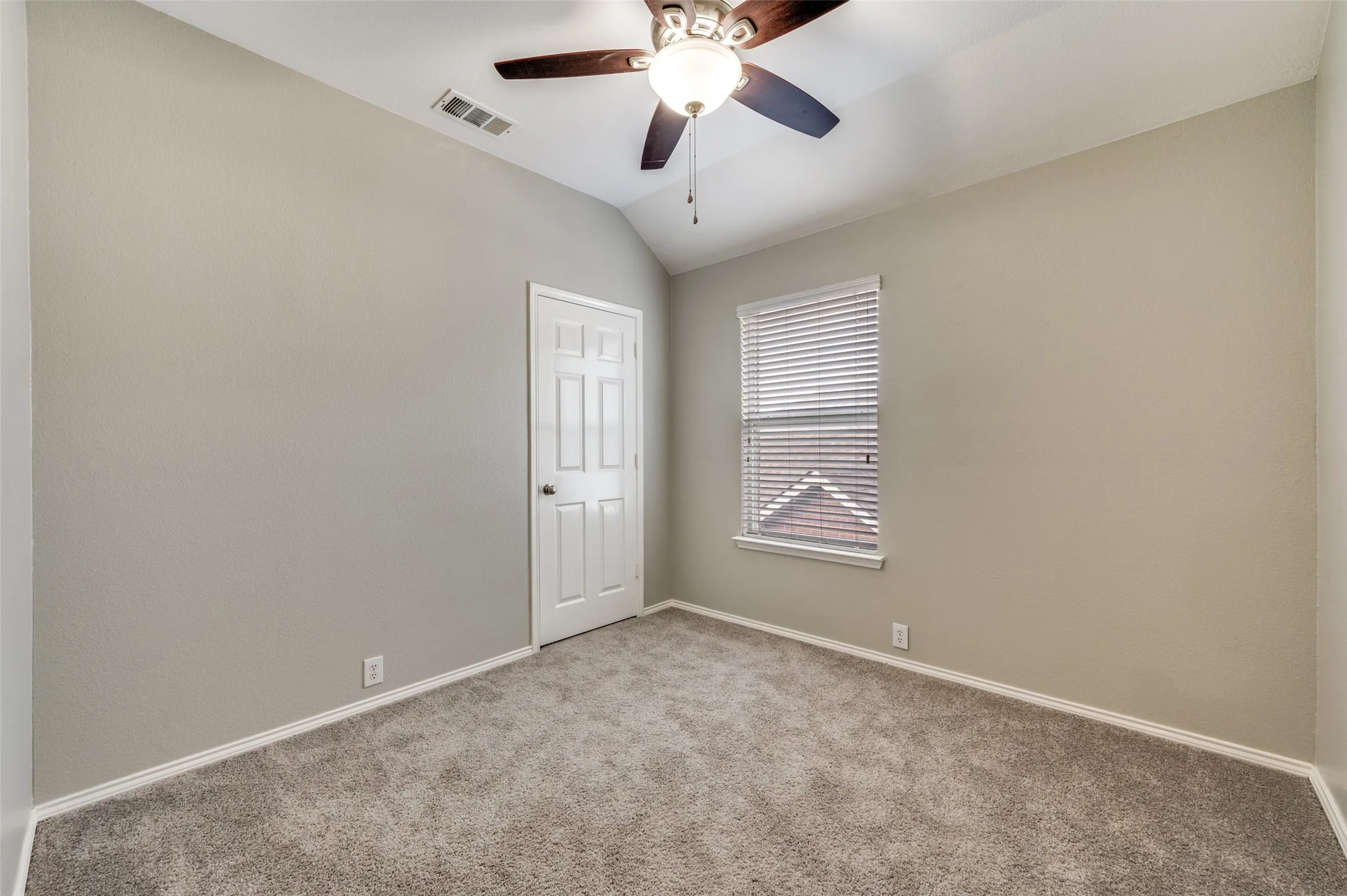 Bedroom 3 Vaulted ceiling with a ceiling fan light fixture, wall-to-wall carpeting, window with blinds, and a paneled interior door