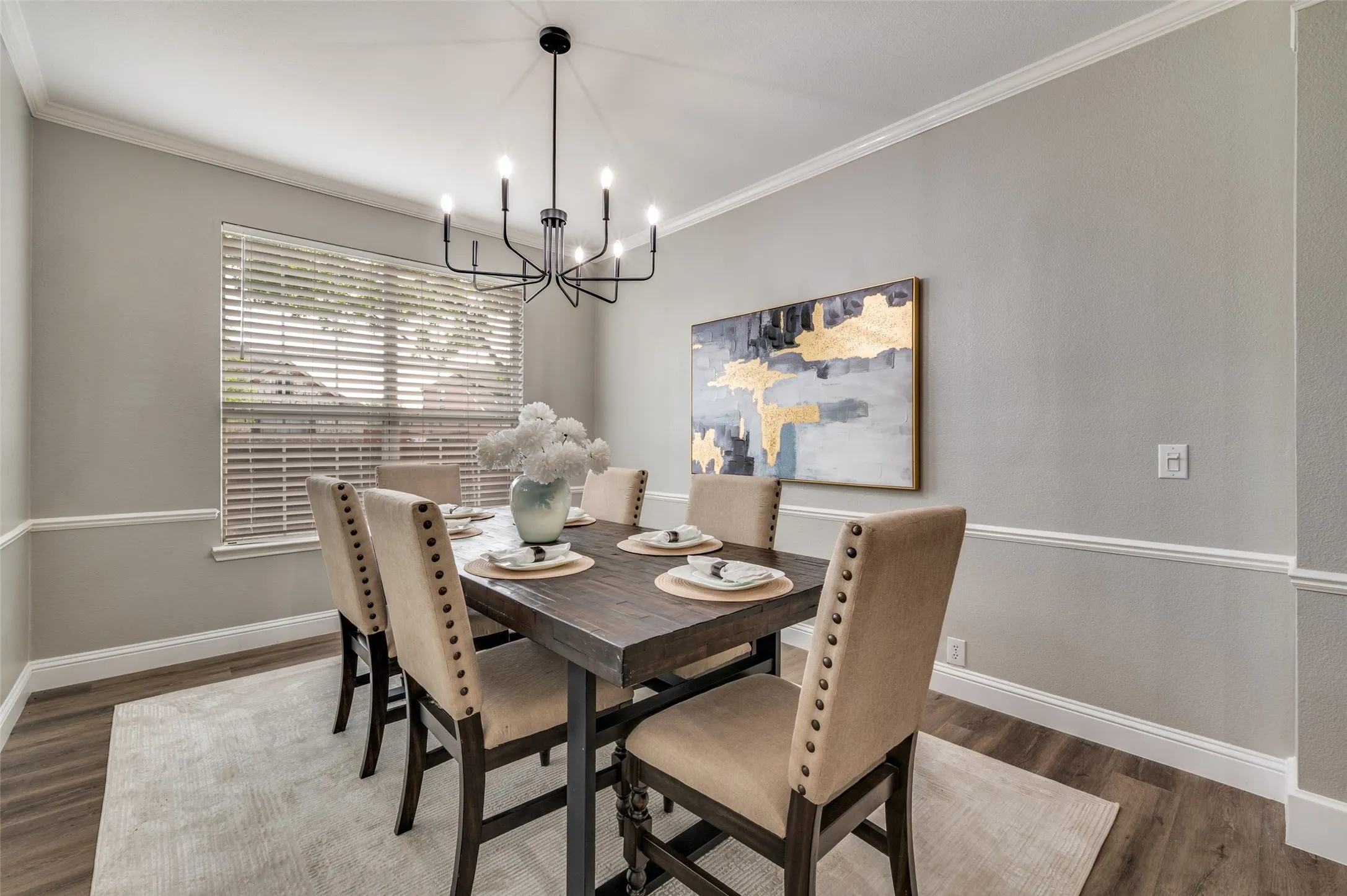 Wood-finish flooring with crisp white crown molding and chair rail detailing