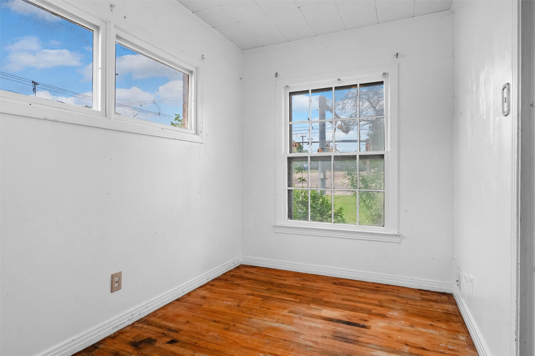 Wood-finish flooring with white trim and multiple windows