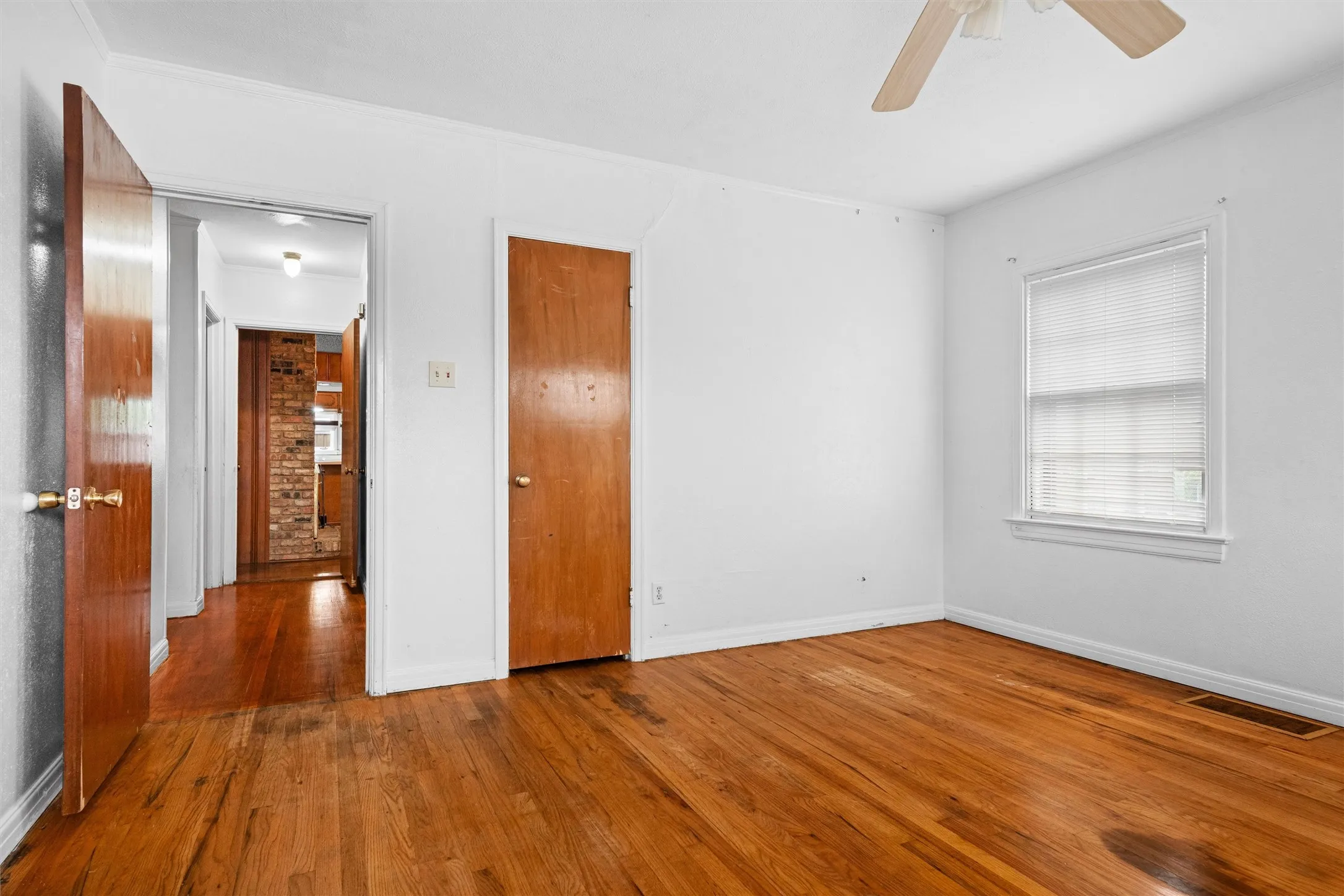 Hardwood flooring, white walls, and a ceiling fan