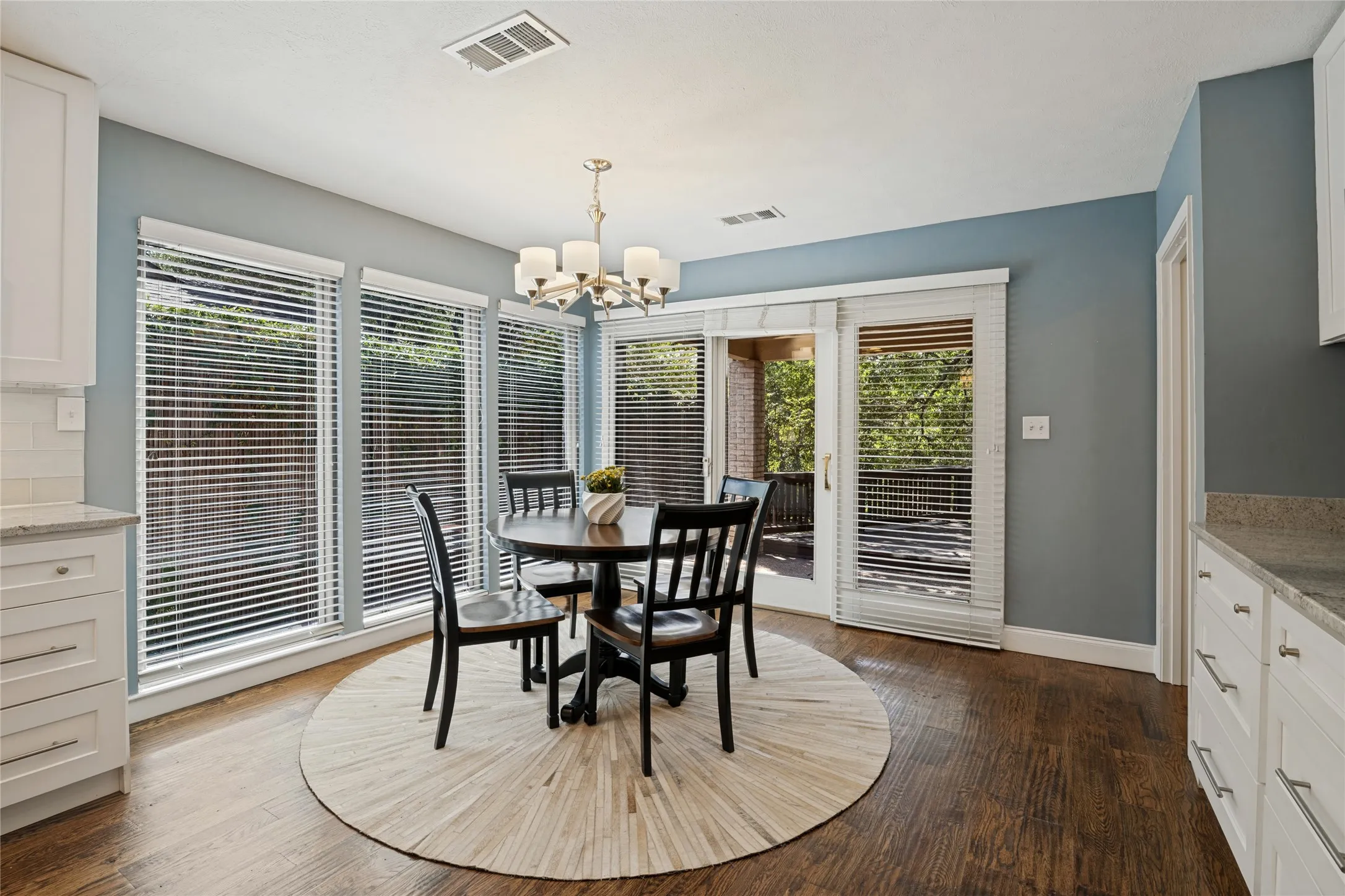 Breakfast room, surrounded by windows, provides more storage and a serving counter.  Access to the covered patio, deck, yard, and creek.