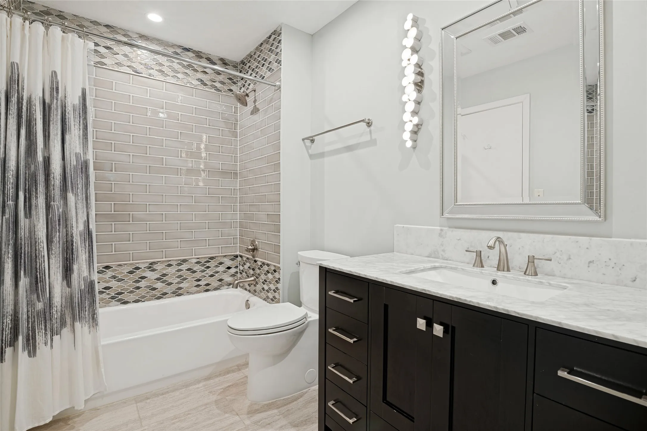 Spacious Bath between Bedrooms 2 & 3 with beautiful vanity cabinet, tile treatments and lighting.