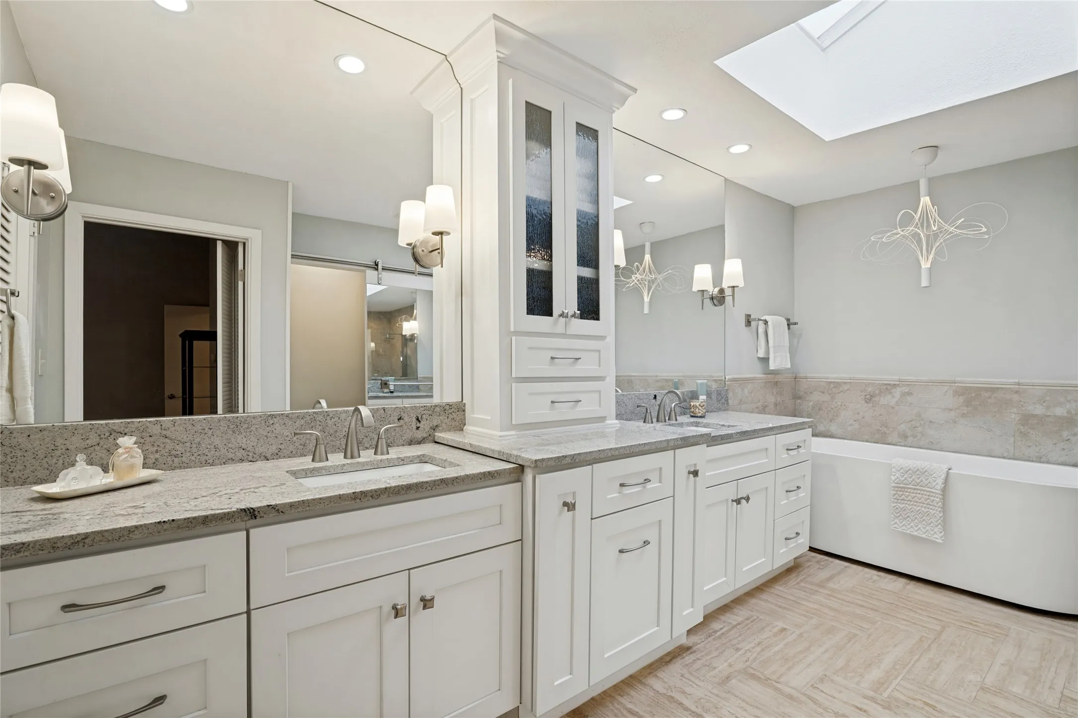 The dream Primary Bath has skylight, separate vanities, vessel tub, and frameless glass shower.