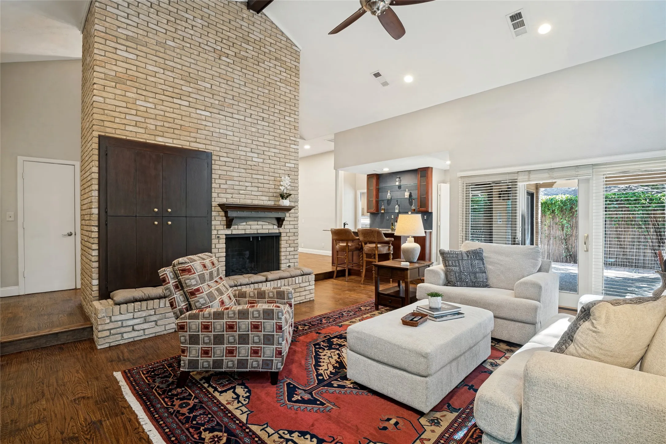View of the floor-to ceiling fireplace and wet bar and Dining Room beyond.