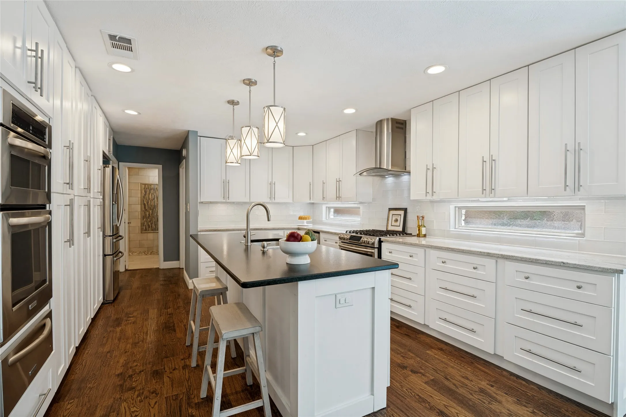 Fabulous custom designed kitchen features island with breakfast bar, pendant lighting, and top appliances.