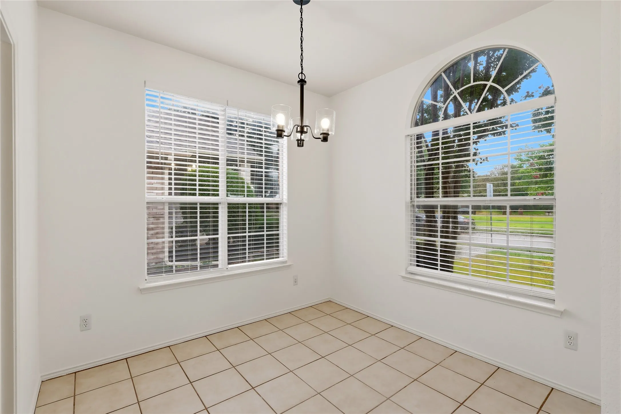 Tiled flooring complemented by a prominent arched window and a standard rectangular window