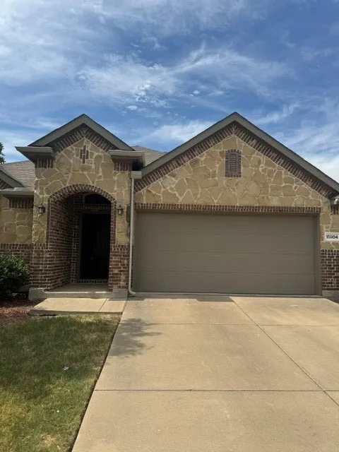 Striking stone and brick exterior with arched entryway and decorative corbelling