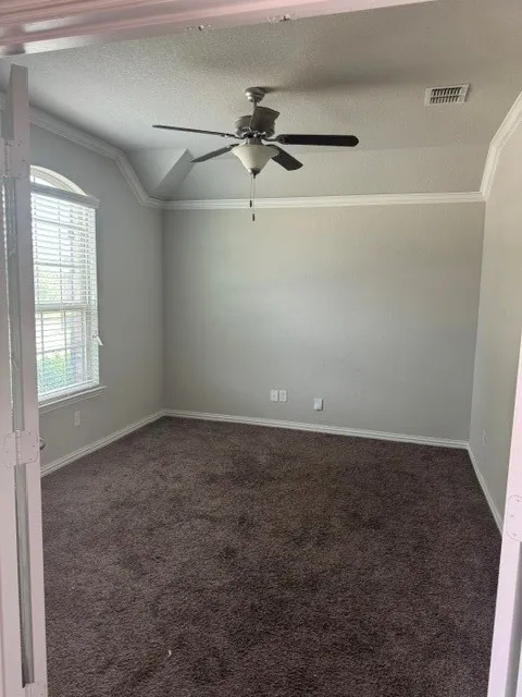Room featuring a ceiling fan, crown molding, and neutral wall paint
