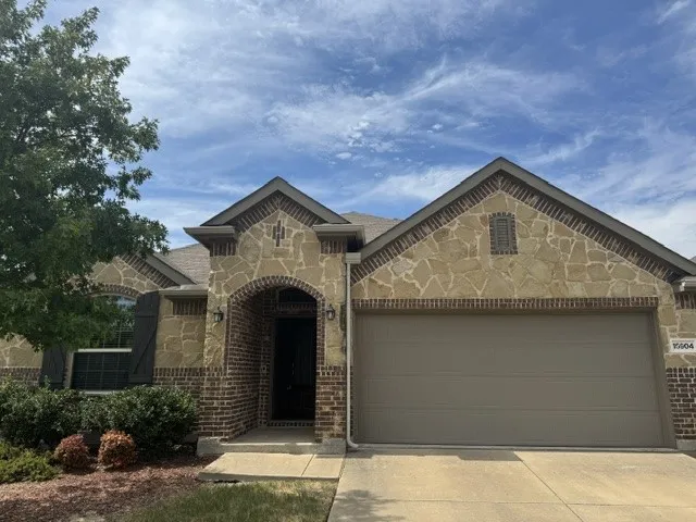 Stunning brick and stone exterior featuring a two-story gabled roofline with detailed architectural trim