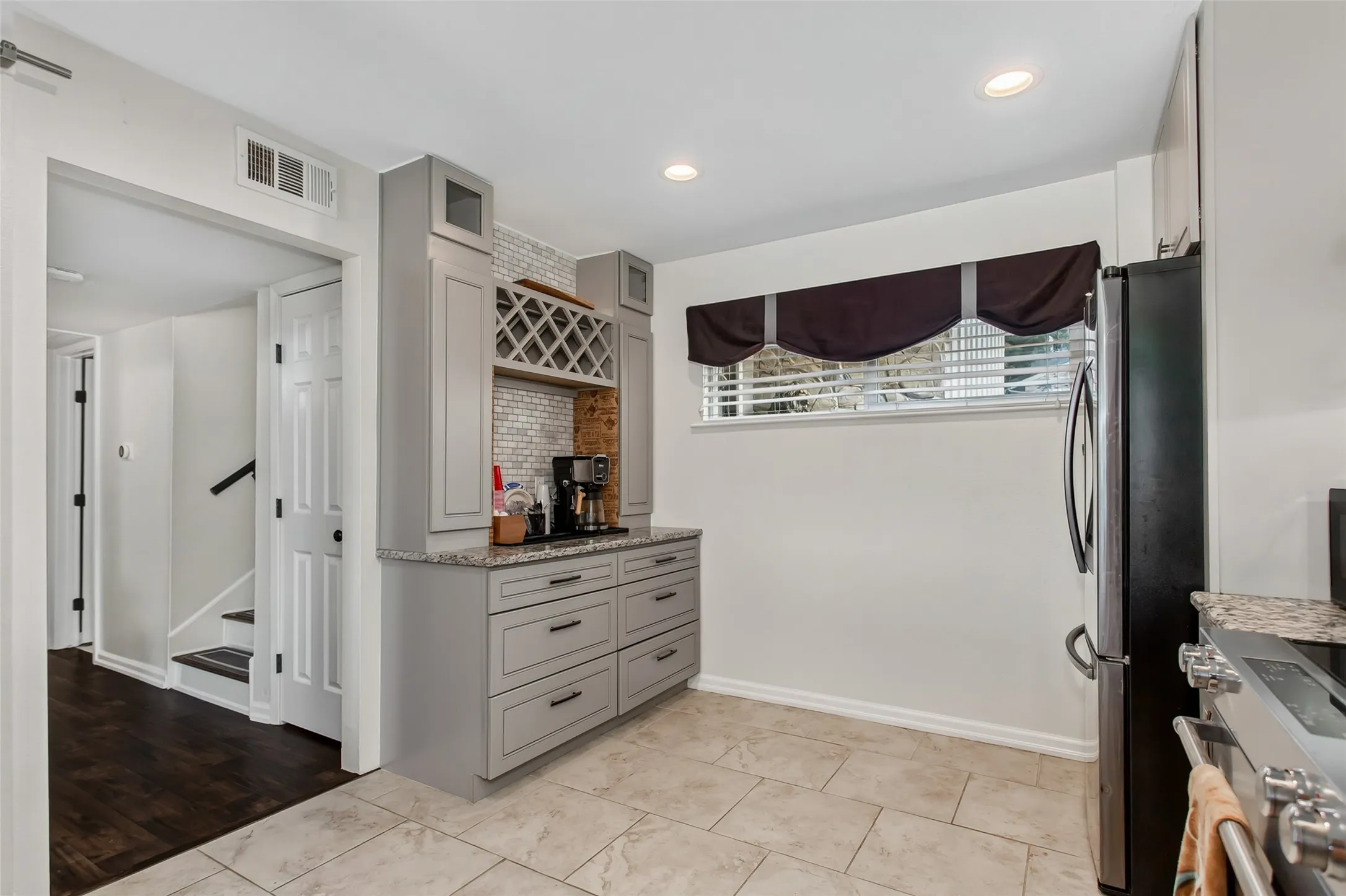 Built-in beverage station with gray cabinetry and wine storage
