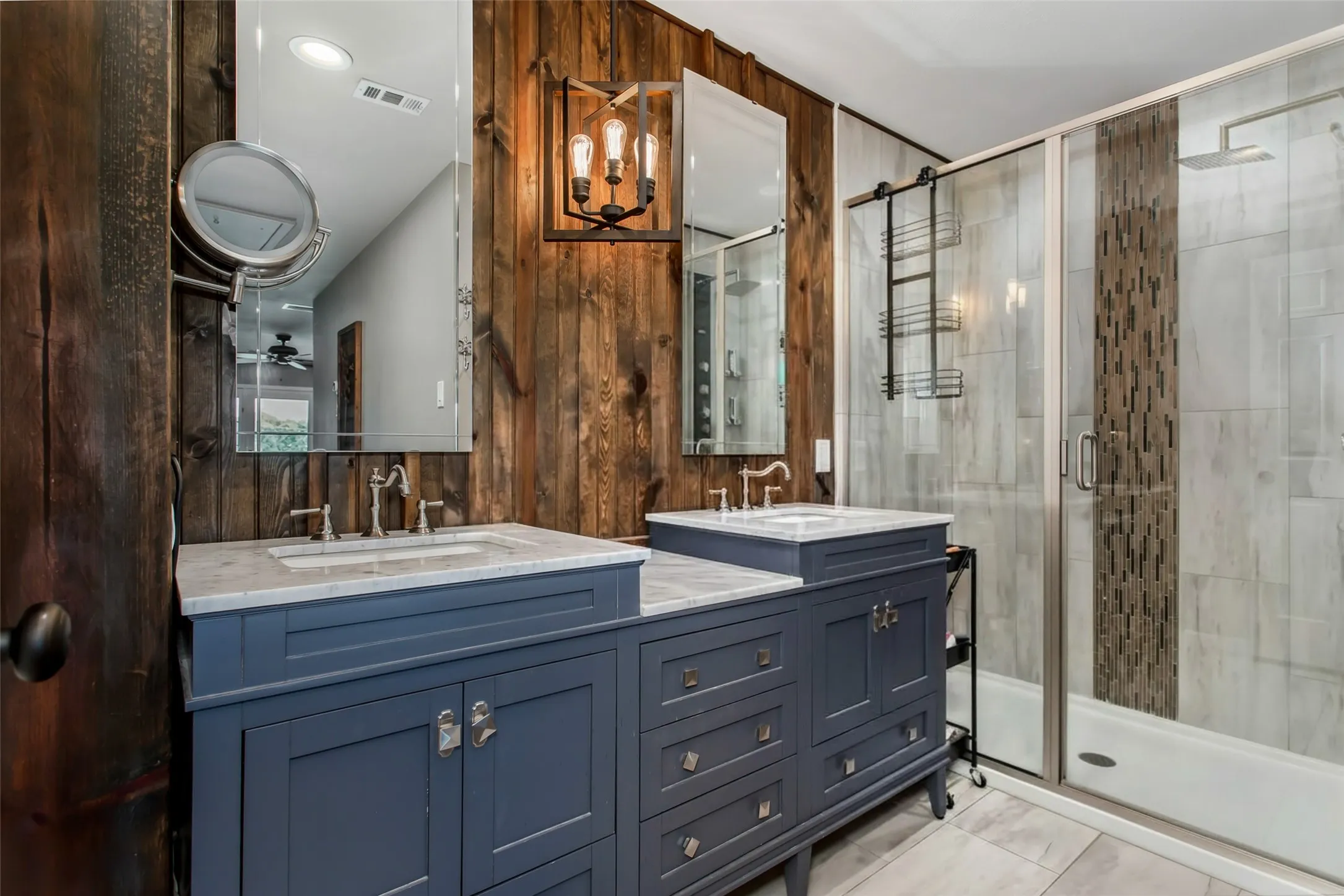 Dual vanity with blue cabinetry and light-toned countertops